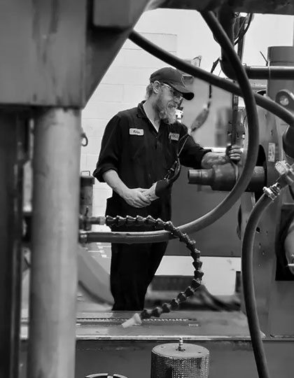 A man working on blue machine in black and white
